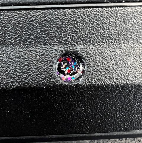 Photo of a screw thats been covered with a unique pattern of (multi-color) glitter nail polish